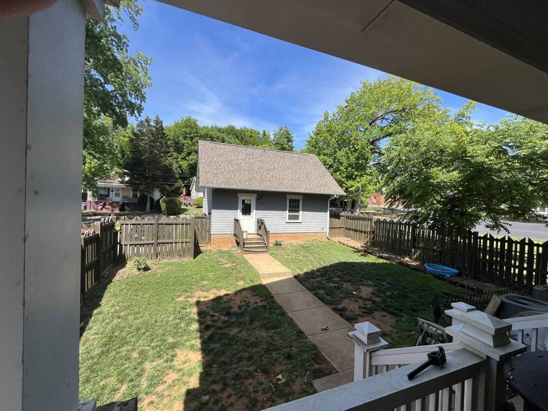 Backyard before: patchy grass and bare clay, seen from the back porch