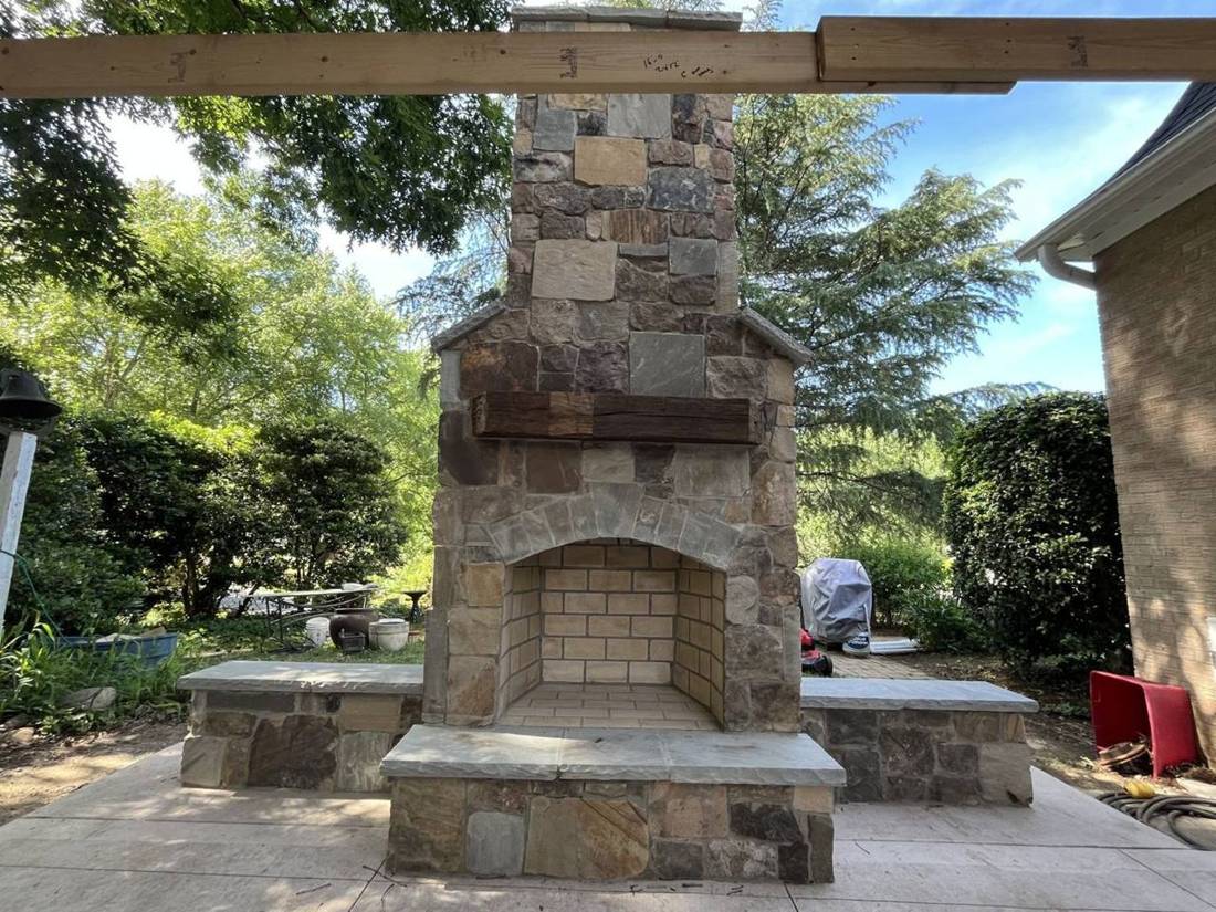 Finished stone fireplace with wood mantel and bluestone hearth