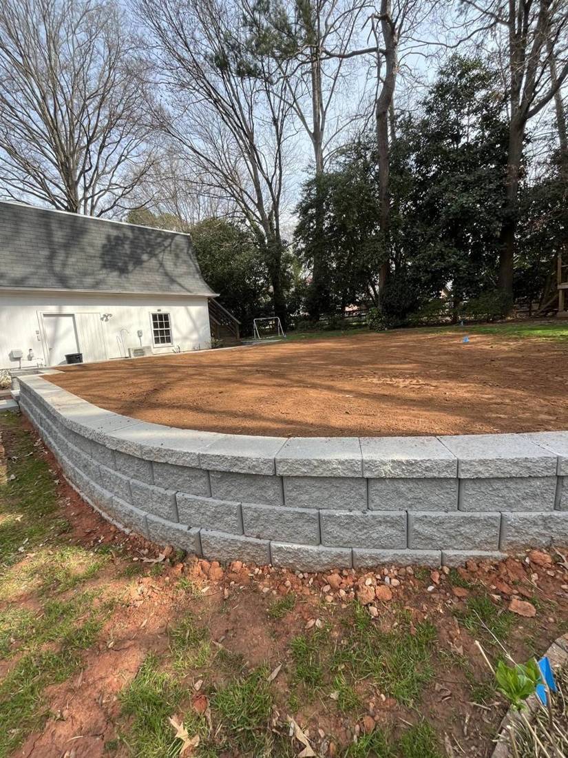 Curved block retaining wall with fresh grading behind it