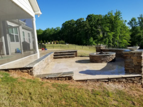 Natural stone terraced patio with seating wall and fire pit