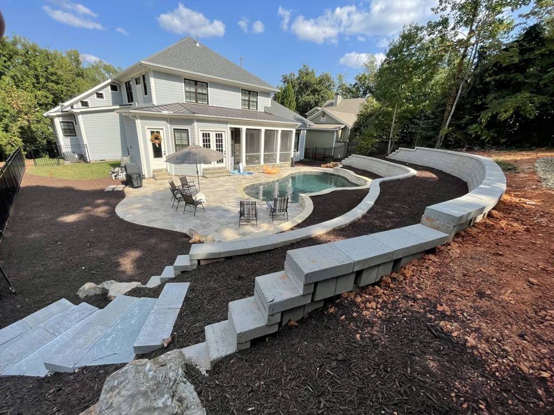 Finished pool deck with terraced walls and mulch beds